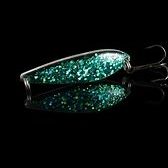 Belly Dancer Glittrande fiskeagn i grönt och silver med krok, reflekterande bakgrund.